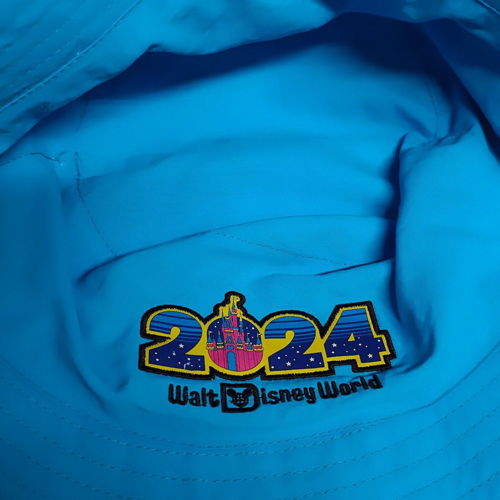 Blue Disney World reversible bucket hat with 2024 logo and castle, part of Mickey Mouse & Friends Four Parks